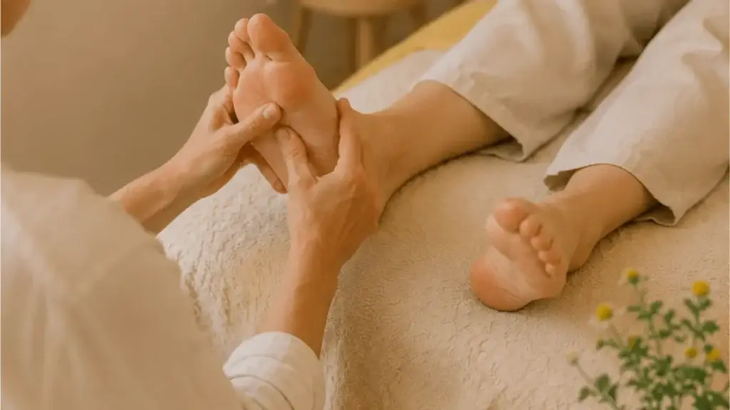 Therapeutin behandelt die Fußreflexzonen einer Patientin.